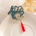 Nahaufnahme einer Vintage-Kranich-Brosche mit blauem Emaille und roter Quaste - XZ197 Kranich