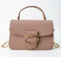 Front view of a pink pebble grain handbag with a gold oval buckle and chain - Pink