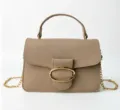 Close-up of textured beige leather handbag with gold oval buckle and chain - Camel