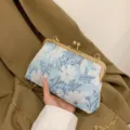 Elegante hellblaue Clutch mit Blumenstickerei, goldenem Kussverschluss und Kettenriemen - Blau