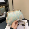 Hellblaue Muscheltasche mit Blumenstickerei, elegantem Klickverschluss und Goldkette - Grün