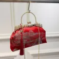 Elegante rote bestickte Abendtasche mit goldenem Quastenanhänger und Kettenriemen. - Burgunderrot