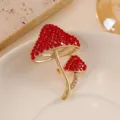Close-up of elegant gold-toned mushroom brooch featuring vibrant red rhinestones. - Red Mushroom