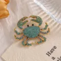 Close-up detail of a creative gold-toned alloy crab brooch with blue rhinestones - XZ158 Crab (XZ158) / Blue