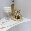 Detail of the high-gloss gold metallic fortune bag evening clutch with gold chain - Gold