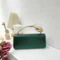 Elegant green weave pattern clutch bag with unique gold bird-shaped handle detail. - Green