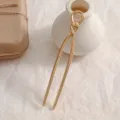Detail view of a gold U-shaped hairpin with an elegant knotted design accent - Gold Twist (12.3x2cm)