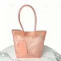 Peach pink TPU jelly tote bag featuring a matching pouch on a stylish marble table. - Pink