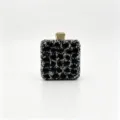 Detail view of luxurious black gemstone evening clutch with sparkling gold clasp - 12.5x7x15cm / Black