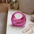 Detailansicht einer leuchtend pinken Acryl-Abendtasche mit glitzernden Strass-Quasten - Rosa