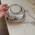 Detailed view of silver evening clutch featuring sparkling rhinestone fringes and ring handle - Silver