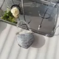 Macro view of a silver heart-shaped evening bag fully adorned with sparkling rhinestones - Silver Flat Rhinestone