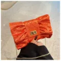 Élégante pochette de soirée orange avec nœud en strass et chaîne en métal doré. - Orange