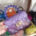 Detail view of purple transparent quilted mini jelly bag featuring a beaded handle - Transparent Purple