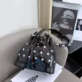 High-quality detail of a black polka dot TPU jelly bucket bag with silver clasp - Polka Dot Pattern / Black