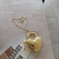 Detailansicht einer luxuriösen, goldglänzenden Herz-Abendtasche aus Acryl mit Kette - 13*4.5*16cm / Gold
