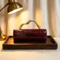 Elegant burgundy crocodile embossed PU leather clutch bag with a unique gold metal handle - Burgundy
