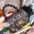 Detailed macro view of a transparent grey quilted jelly bag featuring a black bead handle - Transparent Black