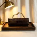 Close-up of vintage brown PU crocodile pattern evening clutch with gold handle - Dark Brown