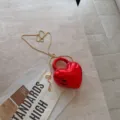 Detailaufnahme der glänzenden roten Abendtasche in Herzform mit edler goldener Kette - 13*4.5*16cm / Rot