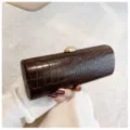 Detailed view of vintage dark brown crocodile pattern texture on long baguette clutch bag - Brown
