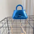 Elegante borsa da sera in acrilico a specchio blu con manico e catena dorata sottile. - Blu