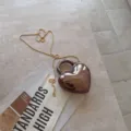 Close-up detail of heart-shaped acrylic evening clutch bag with elegant gold chain strap - 13*4.5*16cm / Black