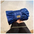 Détail de cette pochette luxe bleu marine en forme de nœud avec strass et chaîne - Bleu