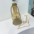 Dettaglio di una mini borsa da sera esagonale ricoperta di strass luccicanti con catena - Oro Tondo Strass Scatola Triangolo