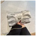 Détail du sac de soirée argenté en forme de nœud avec des strass étincelants. - Argent