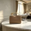 Elegant khaki evening clutch featuring a creative gold rose flower branch handle design - Camel