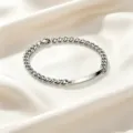 Detailansicht eines Edelstahl-Panzerarmbands mit einer polierten, gravierbaren ID-Platte. - Damenstil / Silber