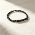 Detailansicht des schwarzen Edelstahl-Cuban-Kettenarmbands mit gravierbarer Platte - Herrenstil / Schwarz