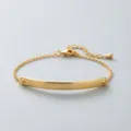 Close-up of a minimalist gold stainless steel bracelet featuring a sleek curved bar detail. - Gold