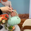 Gros plan d'un sac à main en PVC vert menthe en forme de citrouille avec poignées - 14.5*7.5*10cm / Vert clair