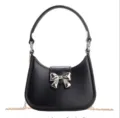 Chic black PVC underarm jelly handbag featuring a silver bow and gold chain strap - Black