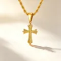 Detailed close-up of a golden stainless steel cross pendant with floral engraving - Gold Cross + Rope Chain