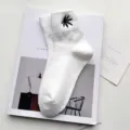 White cotton mid-tube socks featuring a black embroidered leaf pattern, stylish and comfortable. - One Size / White