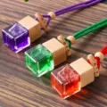 Primo piano di flaconi di profumo colorati per auto con tappo in legno e cordino intrecciato. - Viola