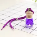 Car perfume bottle detail view, purple liquid crystal glass, wooden cap and hanging rope. - Lavender