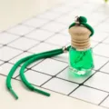 Close-up car perfume bottle detail, hanging glass vial with green liquid and green cord. - Jasmine