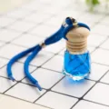 Blue liquid car perfume pendant with wooden cap and hanging rope, clean grid background SKU. - Ocean