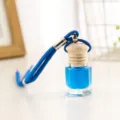 Vista dettagliata della bottiglia di profumo da auto, vetro trasparente e liquido. - Blu
