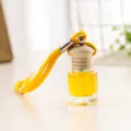 Primo piano del flacone di profumo per auto sospeso con vetro trasparente e corda. - Giallo