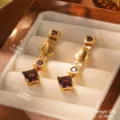 Gros plan macro de boucles d'oreilles vintage en or avec pierres violettes carrées - Colonne Violette (2-28809-6800)