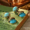 Gros plan détaillé de boucles d'oreilles turquoise vintage de style cour française sur livre - Style de Rétention de Couleur Turquoise (23116B-7000)
