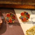 Macro view of colorful enamel flower earrings with gold finish in a vintage palace style - Enamel Gradient
