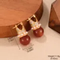 Detailed view of vintage brown tiger eye earrings with gold finish and pearl accents. - Tiger Eye C-Shaped Hollow Style (2-19542A-6500)