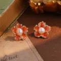 Close-up view of vintage orange enamel flower stud earrings with elegant pearl center - Orange Enamel Pearl Flower Style (22929)