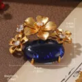 Detail showing vintage gold flower brooch with large oval blue gemstone and rhinestones - Vintage Three Flowers Blue Stone Style (7-3147-6000)